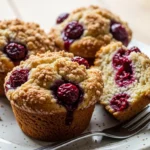 Close-up of warm, delicious cherry cobbler muffins fresh from the oven, showcasing the juicy cherries and golden-brown crumb topping.