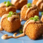 Close-up of golden crispy salmon bites served with zesty bang bang sauce.