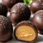 Close-up of a creamy, homemade peanut butter egg coated in rich chocolate, ready to eat.