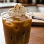 Homemade Iced Pumpkin Chai Latte in a glass with ice and spices, perfect for autumn.
