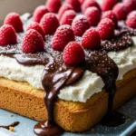 Close-up of a moist vanilla raspberry ricotta cake with chocolate ganache and fresh raspberries.