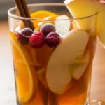 Refreshing Apple Cider Sangria with apples, oranges, and cinnamon sticks. Perfect for a holiday party!