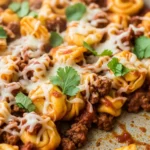 Close-up of cheesy beef enchilada tortellini skillet, ready to eat.