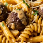 Creamy Cajun meatball pasta recipe served in a pot, ready to eat. One-pot recipe for easy weeknight dinner.
