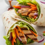 Close-up of a delicious teriyaki chicken wrap, showcasing the juicy chicken and fresh fillings.